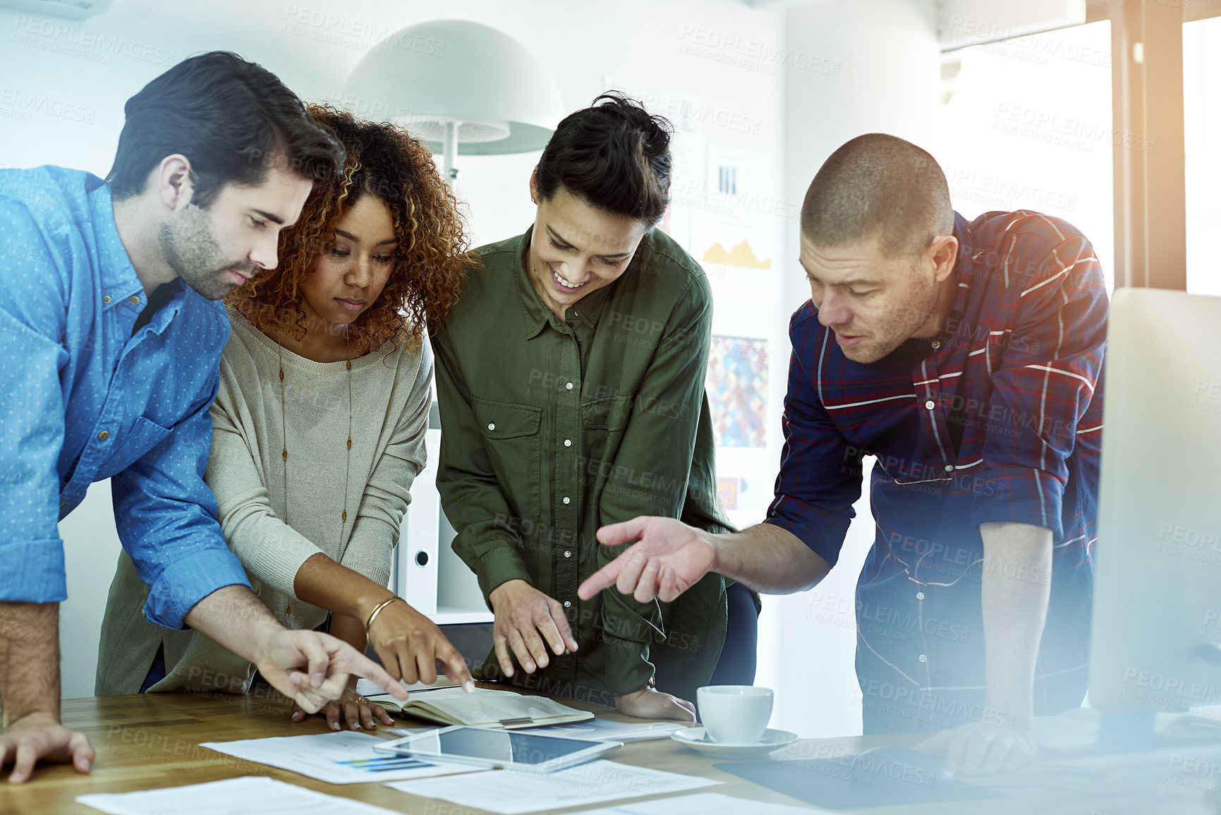 Buy stock photo Cropped shot of a group of coworkers discussing something on a tablet