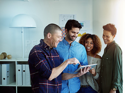 Buy stock photo Cropped shot of a group of coworkers discussing something on a tablet