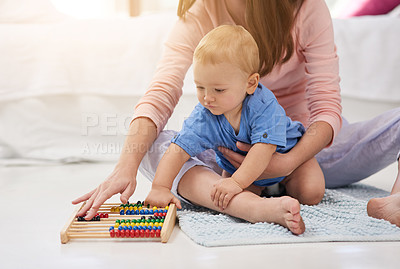 Buy stock photo Cropped shot of a mother and her baby boy counting on an abacus