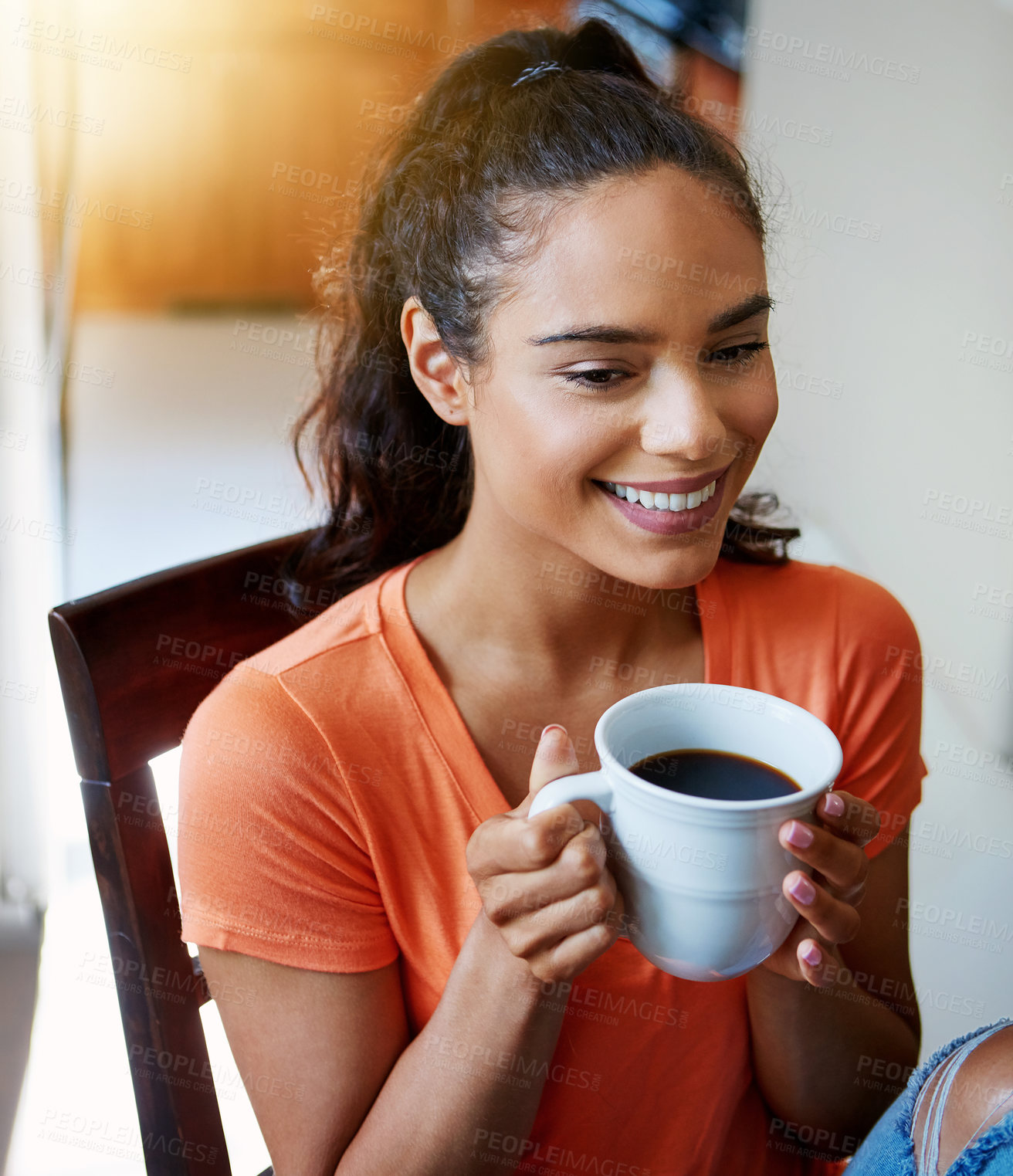 Buy stock photo Shot of a smiling young woman drinking coffee while sitting in a chair at home