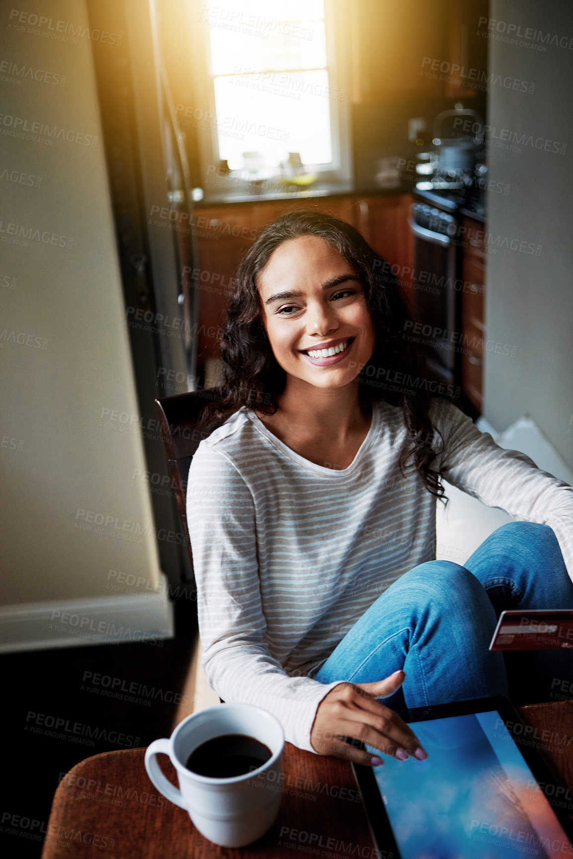 Buy stock photo Shot of a young woman drinking coffee and shopping online with her digital tablet at home