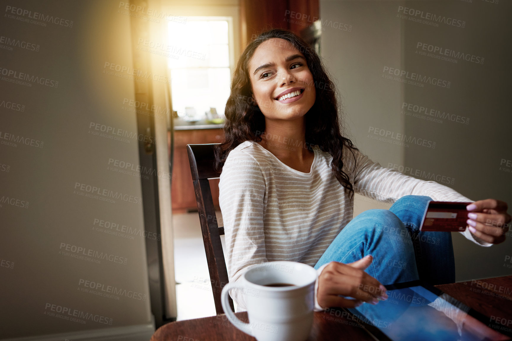 Buy stock photo Shot of a young woman drinking coffee and shopping online with her digital tablet at home