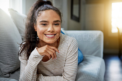 Buy stock photo Portrait of a smiling young woman relaxing on the sofa at home
