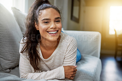 Buy stock photo Portrait of a smiling young woman relaxing on the sofa at home