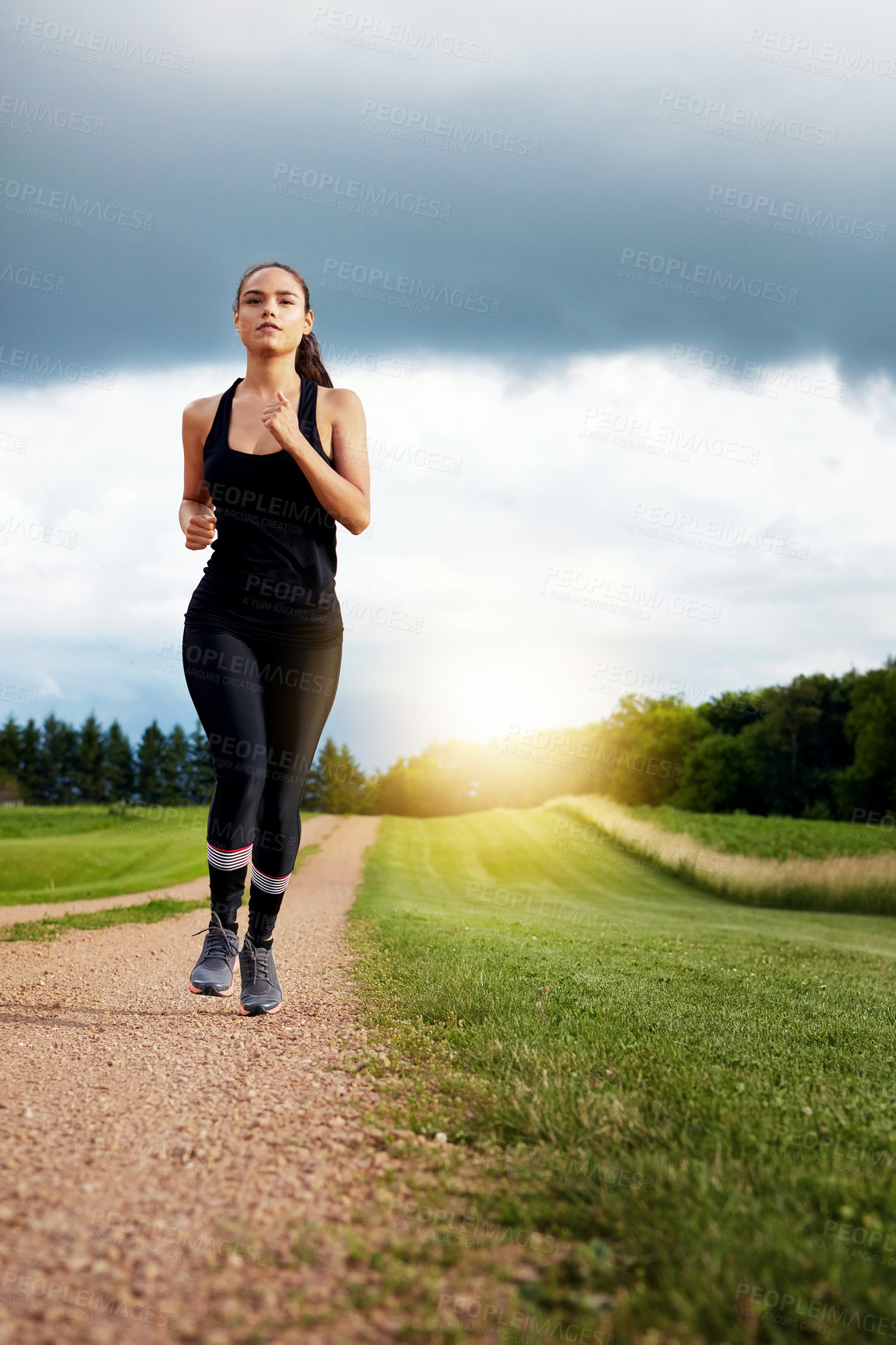 Buy stock photo Shot of a fit young woman out for a run on a beautiful day