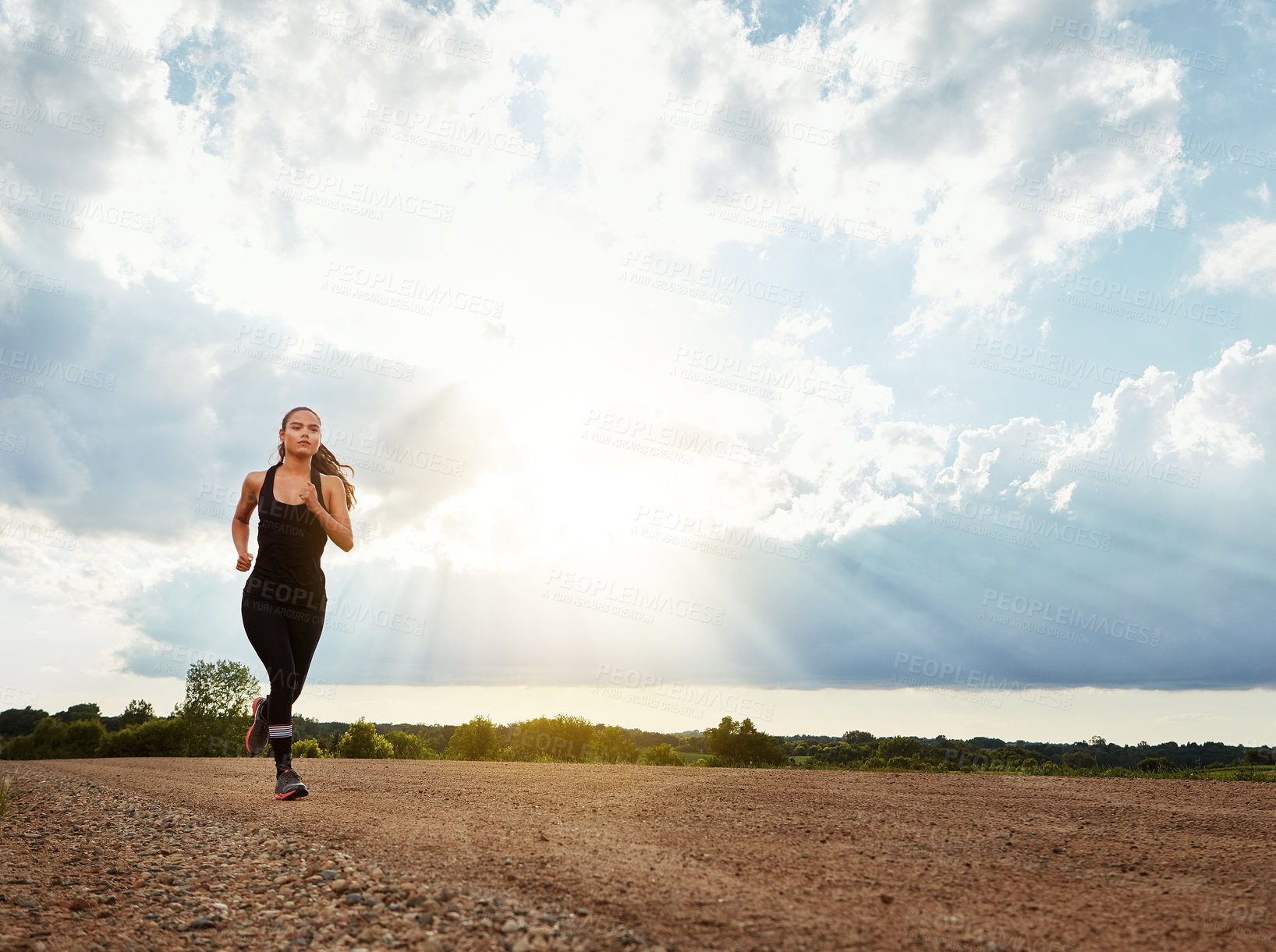 Buy stock photo Shot of a fit young woman out for a run on a beautiful day