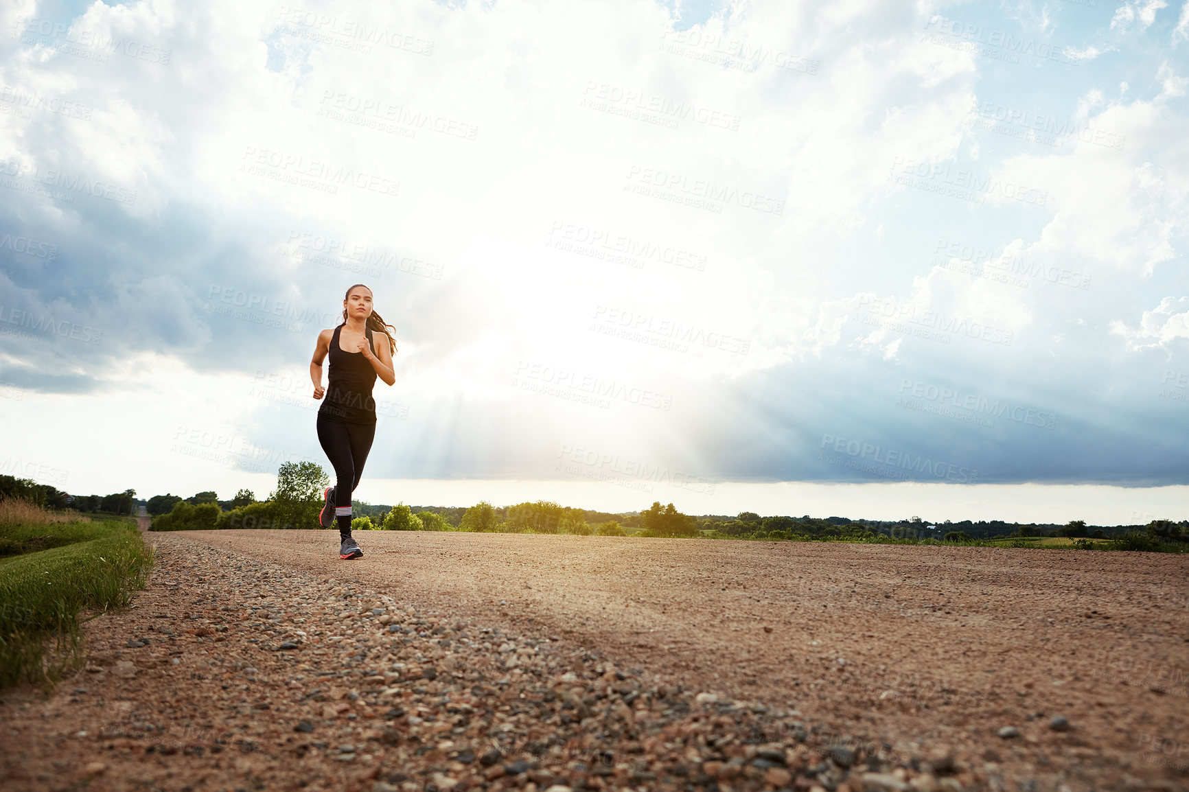 Buy stock photo Shot of a fit young woman out for a run on a beautiful day