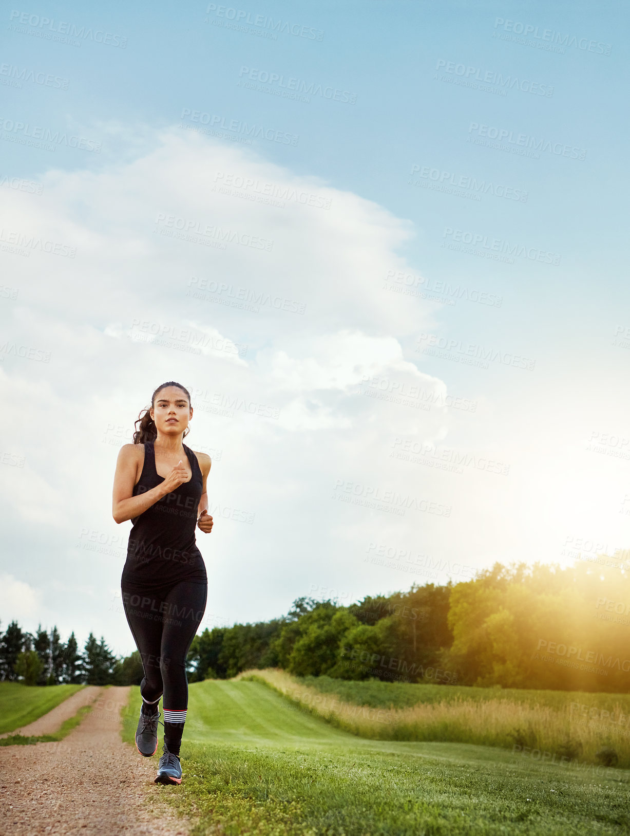 Buy stock photo Shot of a fit young woman out for a run on a beautiful day