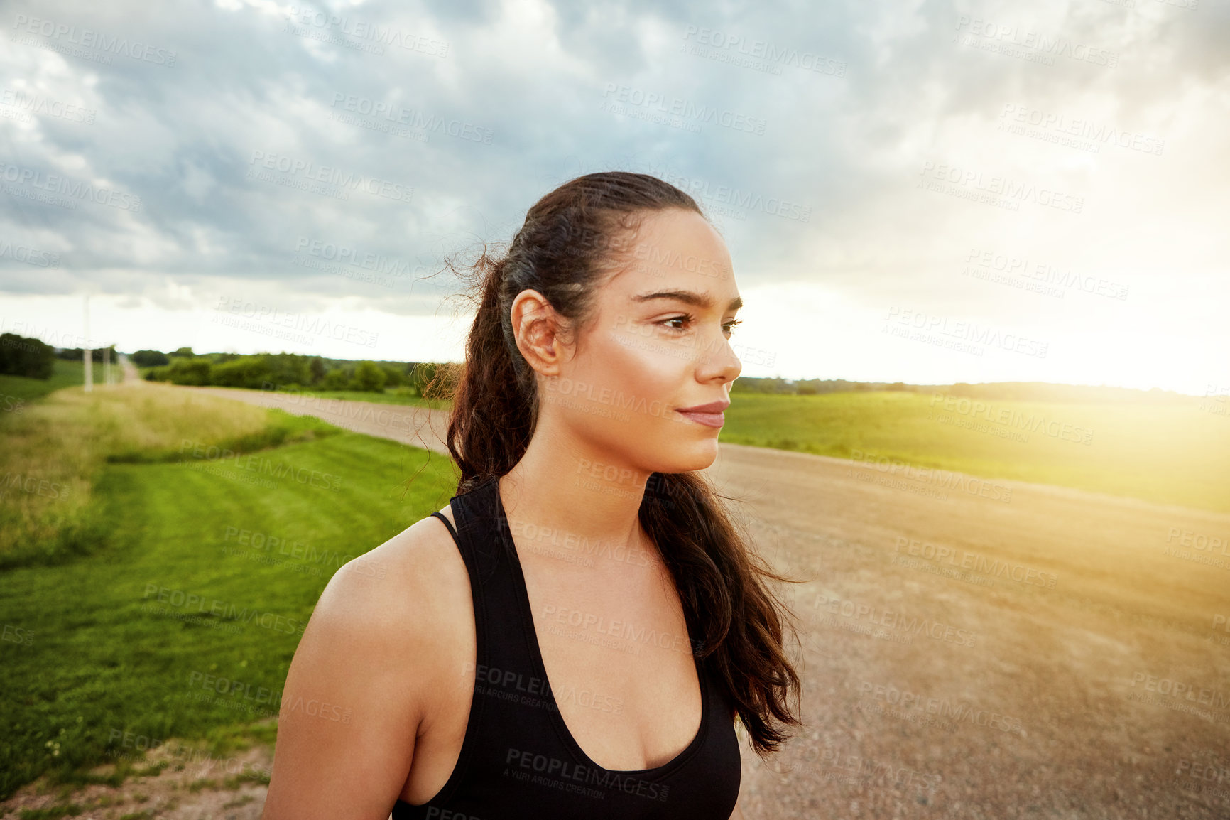 Buy stock photo Shot of a fit young woman getting some exercise outside on a beautiful day