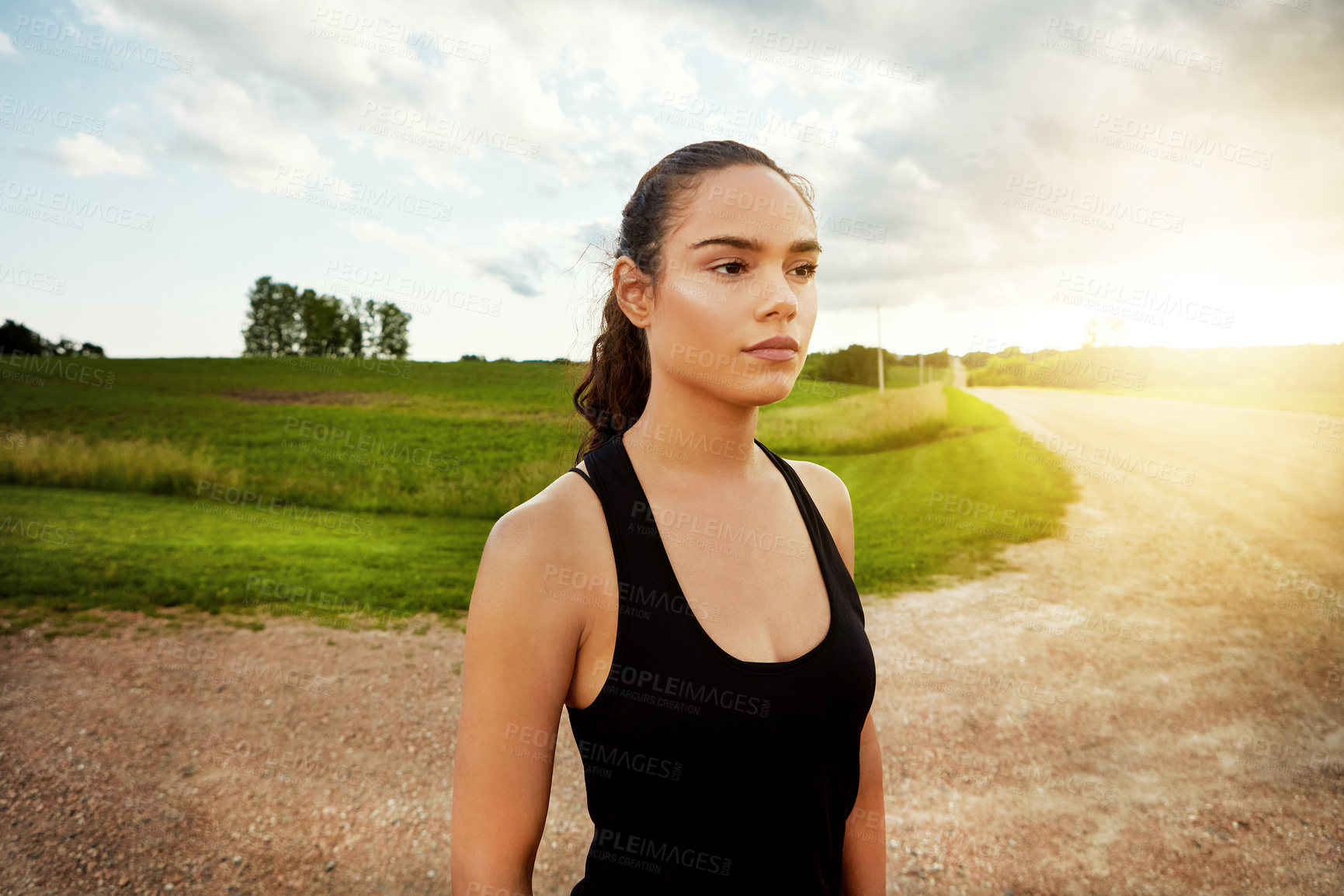 Buy stock photo Shot of a fit young woman getting some exercise outside on a beautiful day