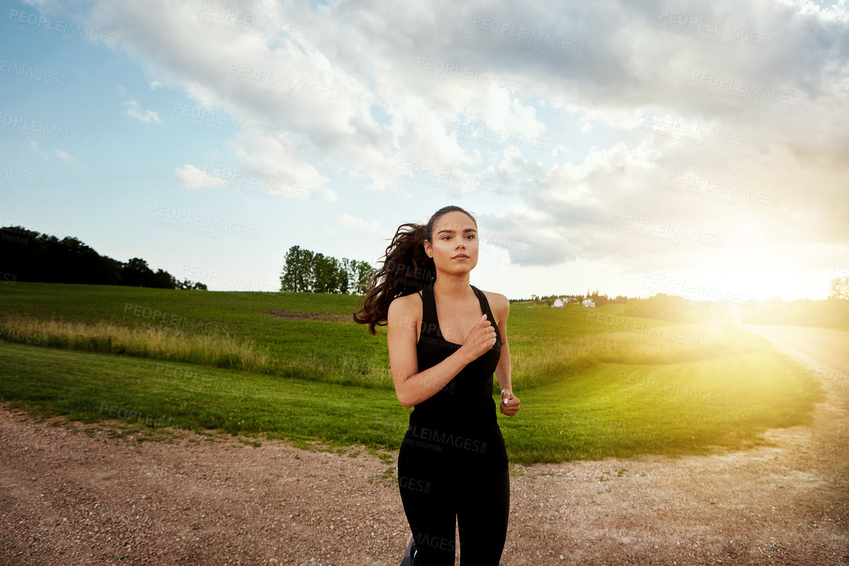 Buy stock photo Shot of a fit young woman out for a run on a beautiful day