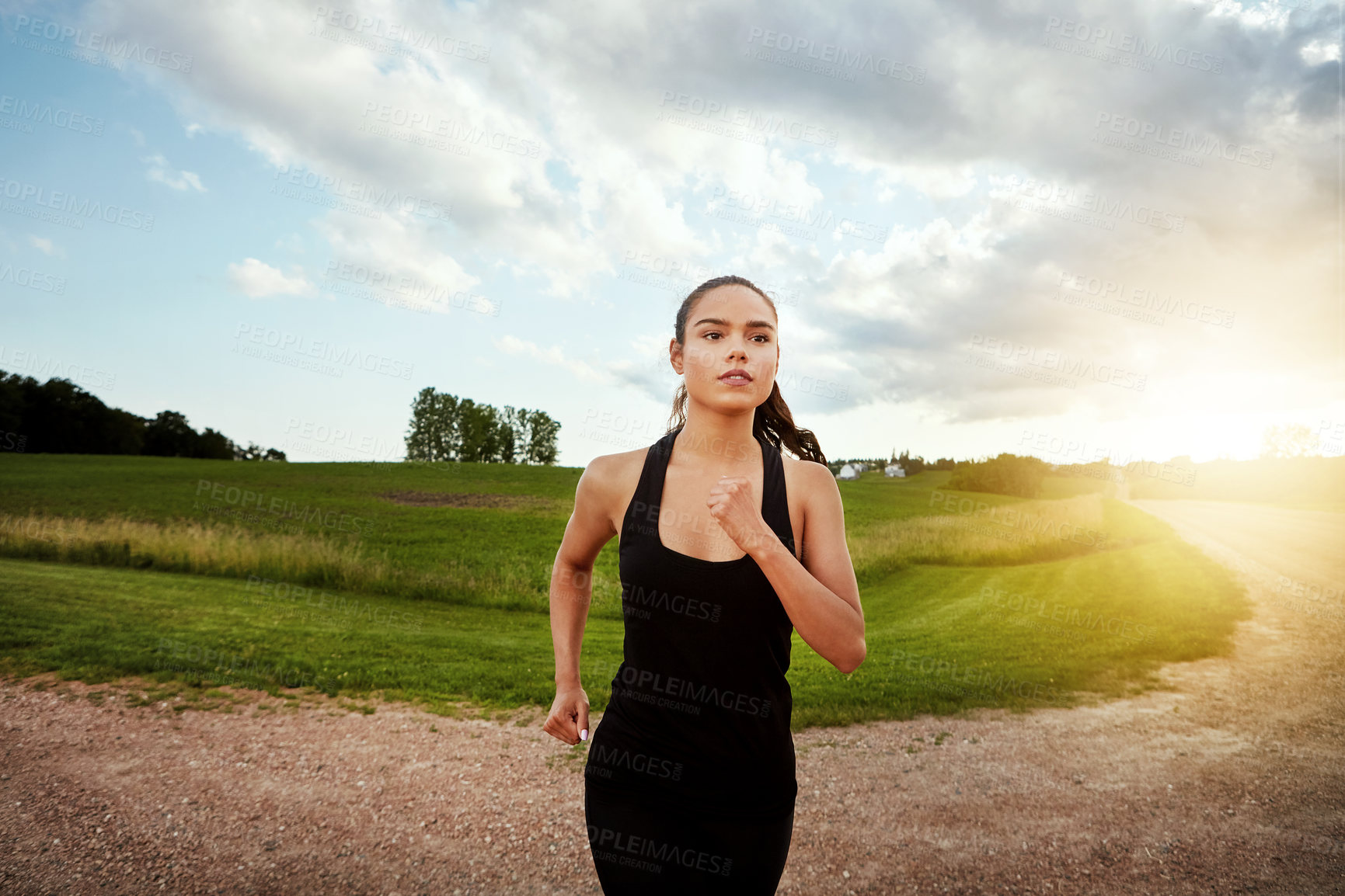 Buy stock photo Shot of a fit young woman out for a run on a beautiful day