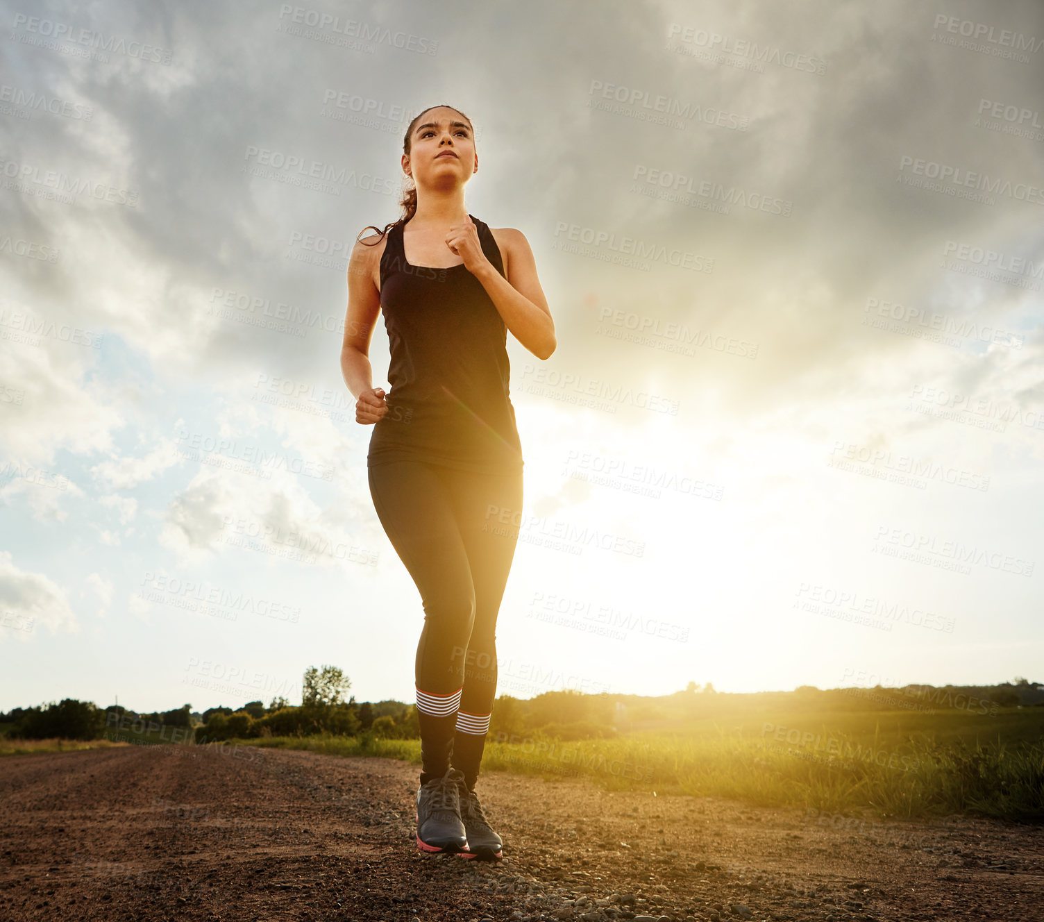 Buy stock photo Shot of a fit young woman out for a run on a beautiful day