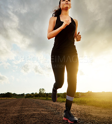 Buy stock photo Shot of a fit young woman out for a run on a beautiful day