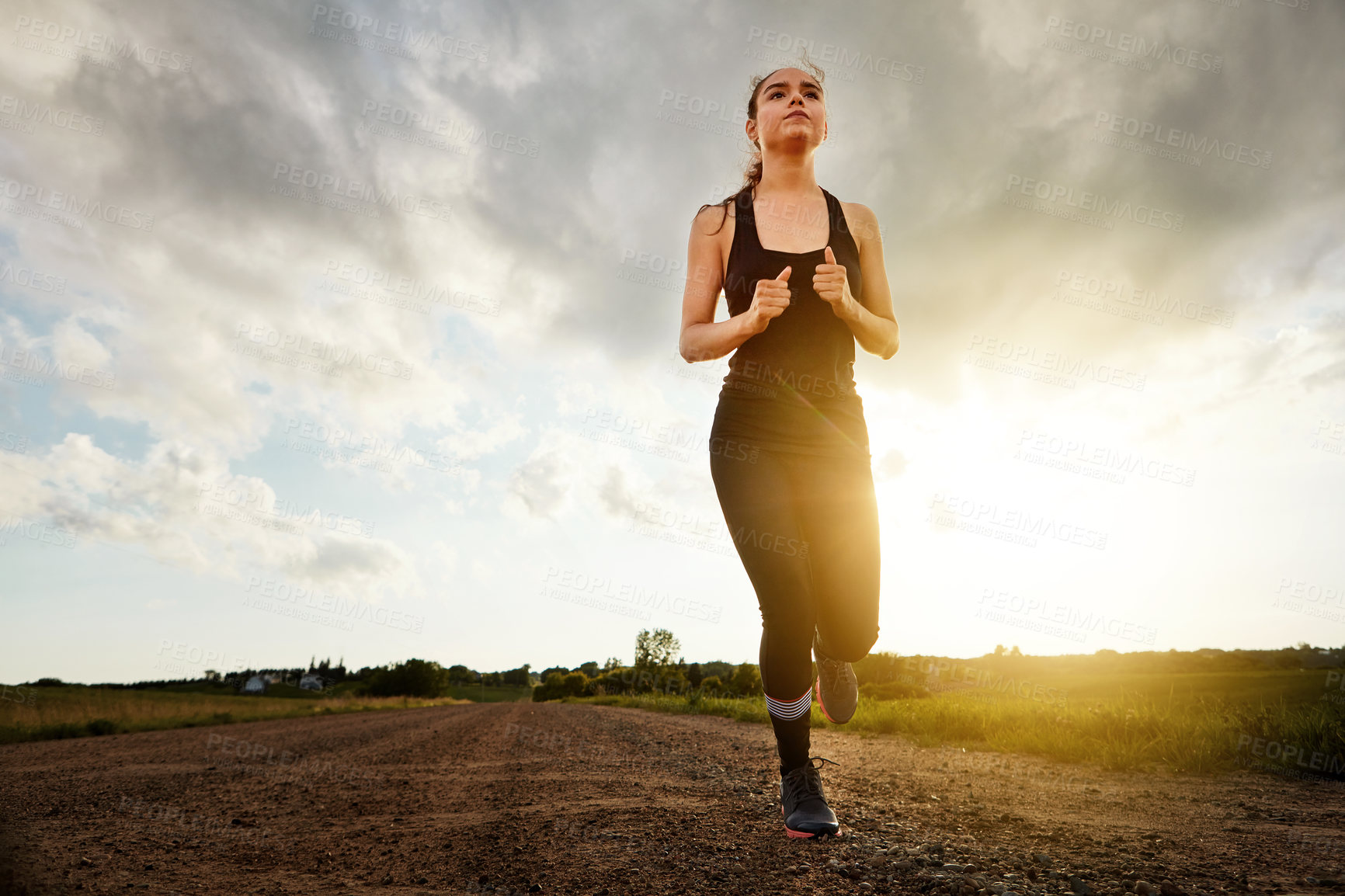 Buy stock photo Shot of a fit young woman out for a run on a beautiful day