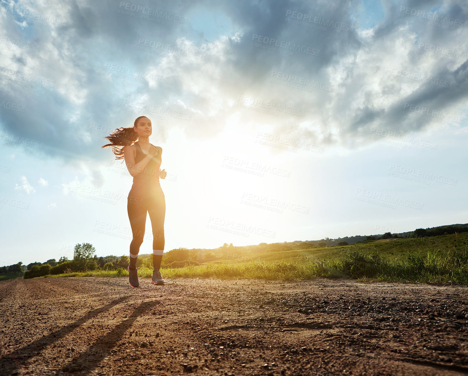 Buy stock photo Shot of a fit young woman out for a run on a beautiful day