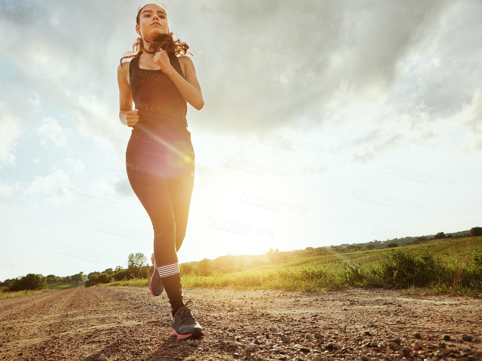 Buy stock photo Shot of a fit young woman out for a run on a beautiful day