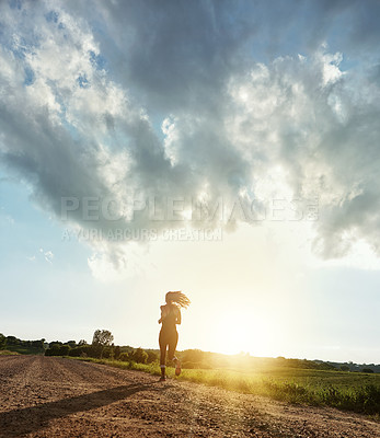 Buy stock photo Rearview shot of a young woman out for a run on a beautiful day