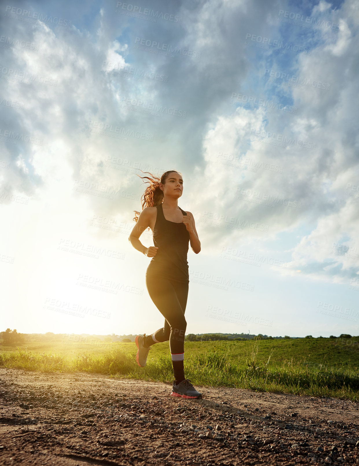 Buy stock photo Shot of a fit young woman out for a run on a beautiful day