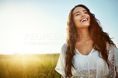 Buy stock photo Shot of an attractive young woman standing outside in a field