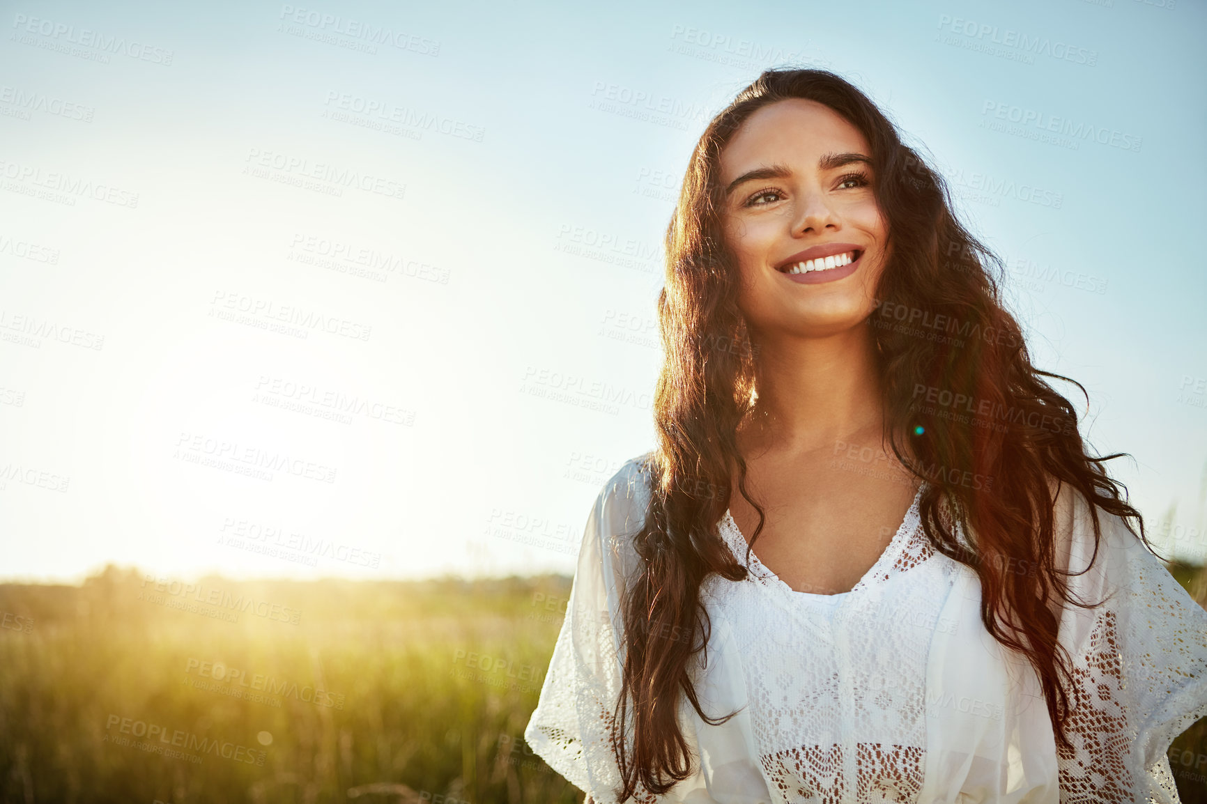 Buy stock photo Shot of an attractive young woman standing outside in a field