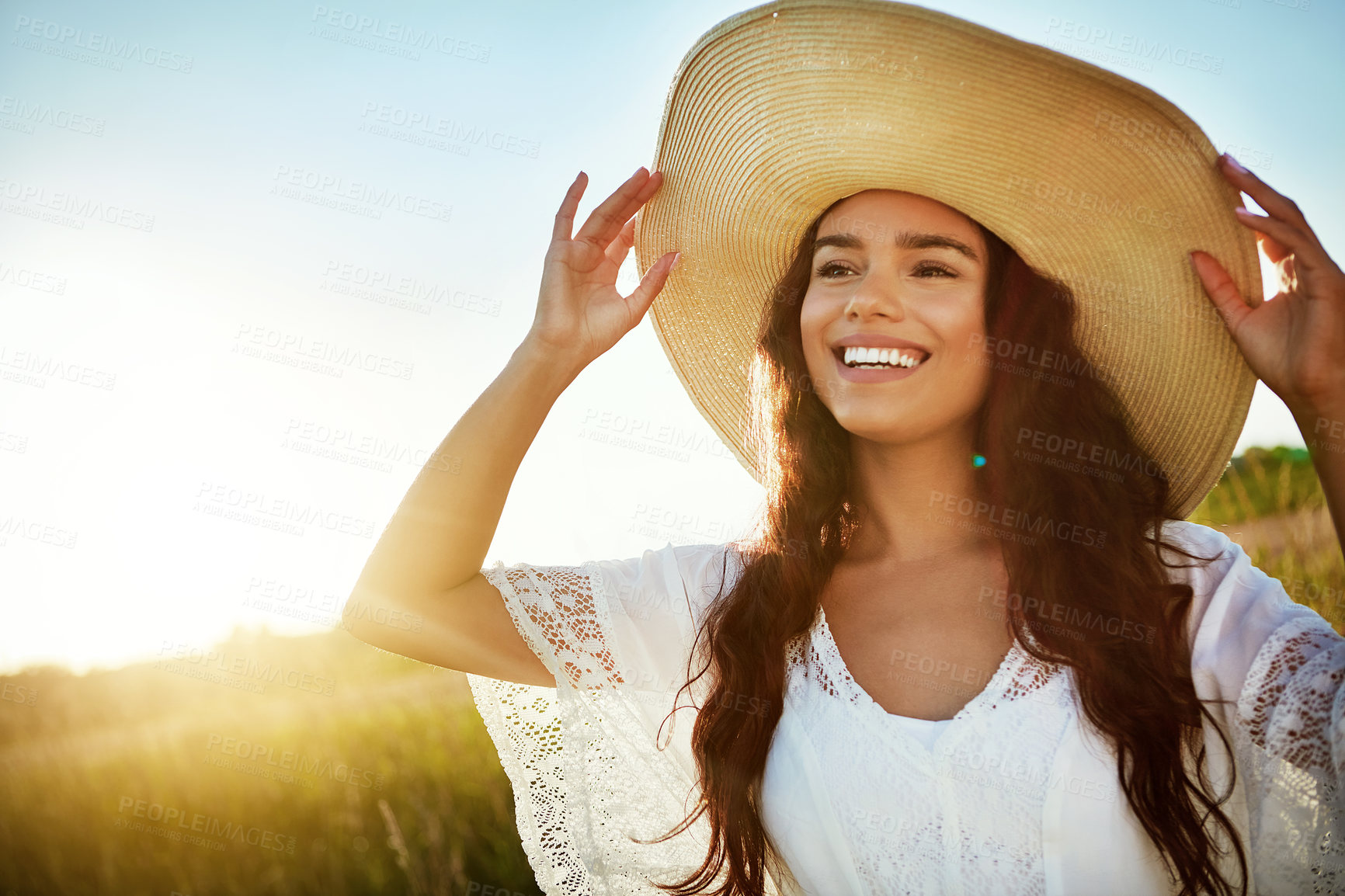 Buy stock photo Shot of an attractive young woman standing outside in a field