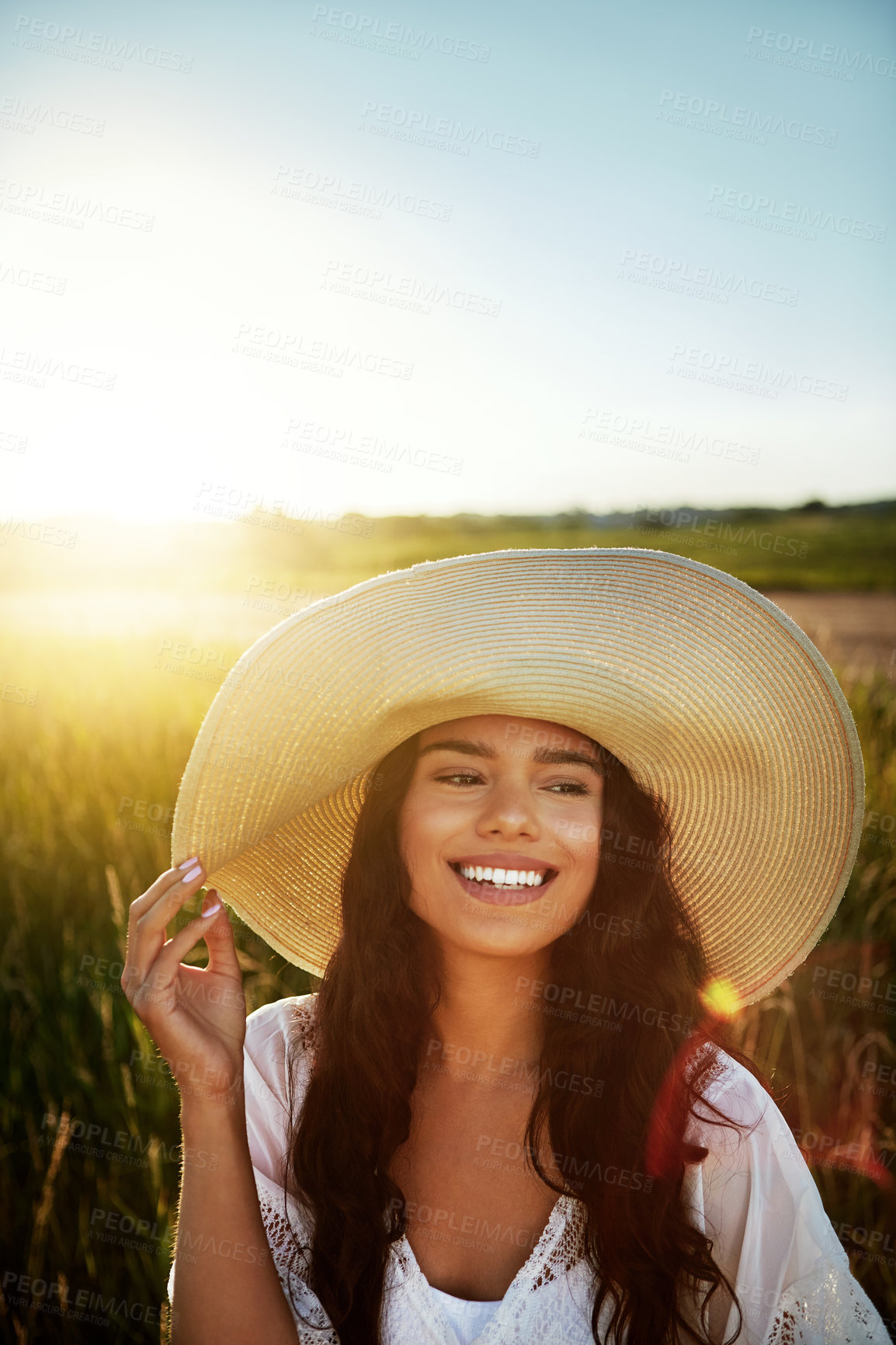 Buy stock photo Shot of an attractive young woman standing outside in a field
