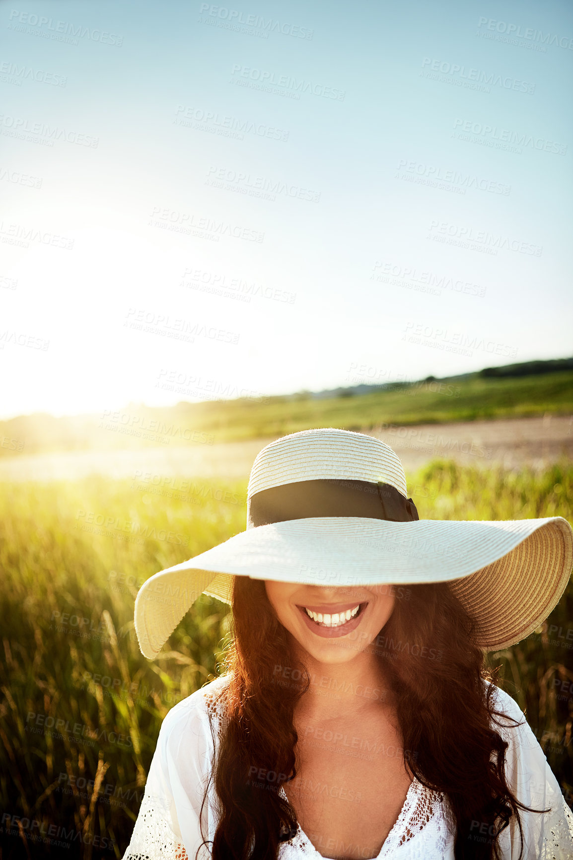 Buy stock photo Shot of an attractive young woman standing outside in a field