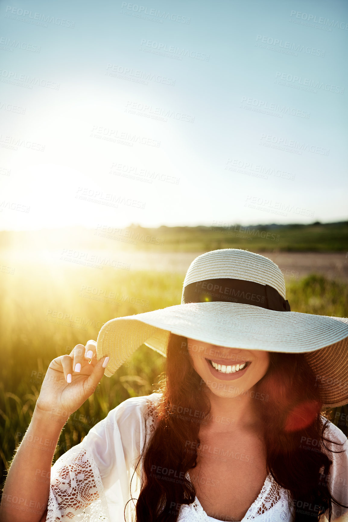 Buy stock photo Shot of an attractive young woman standing outside in a field