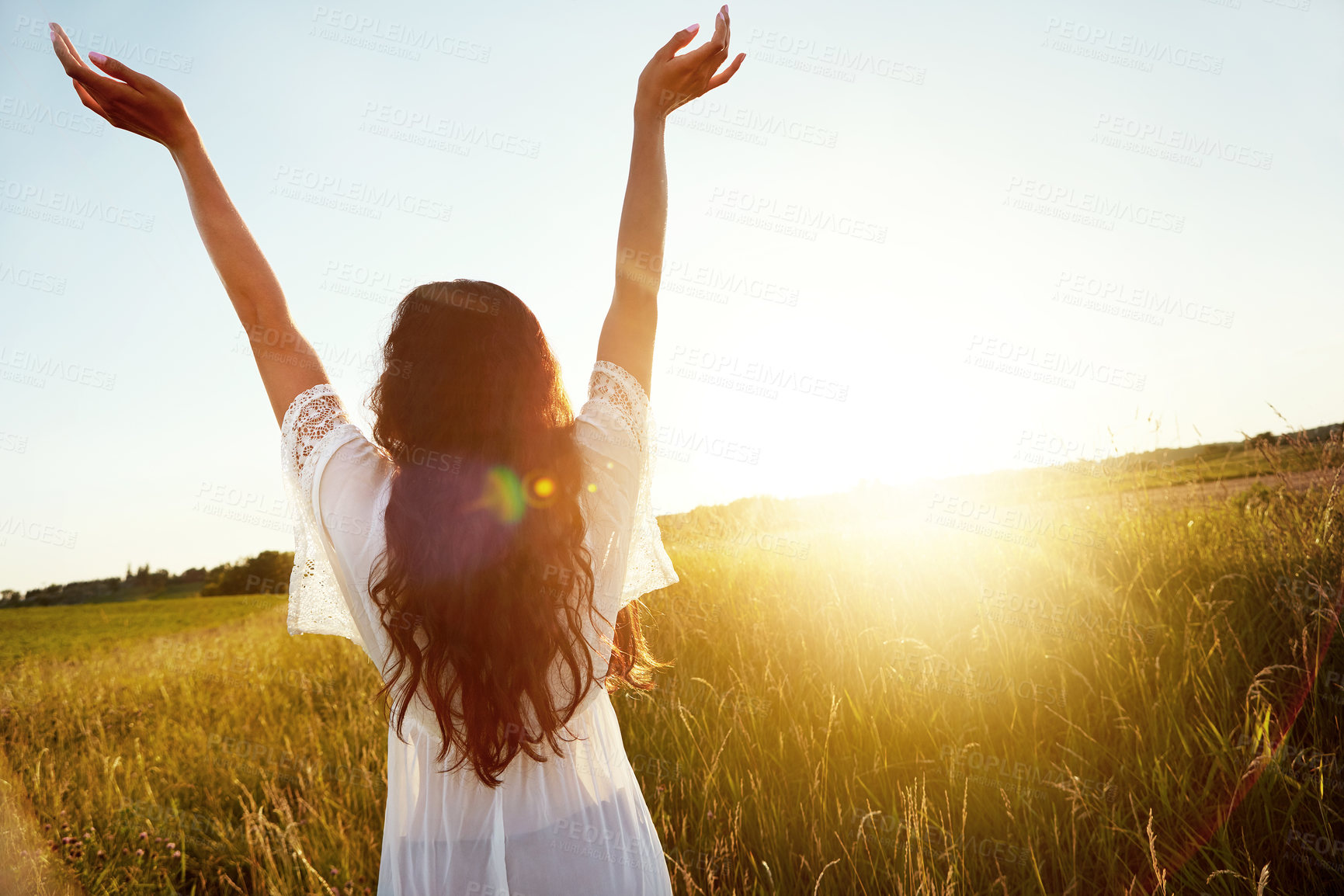 Buy stock photo Shot of an attractive young woman standing outside in a field