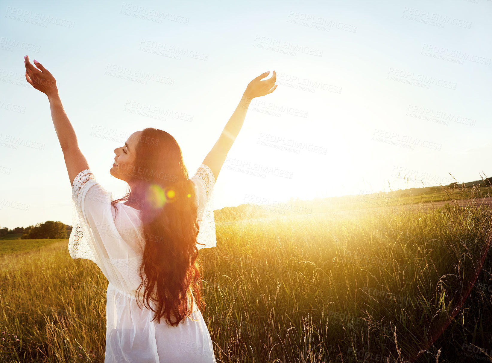 Buy stock photo Shot of an attractive young woman standing outside in a field