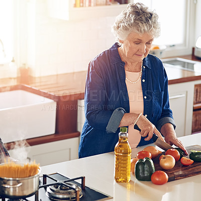 Buy stock photo Cropped shot of a senior woman cooking in her kitchen