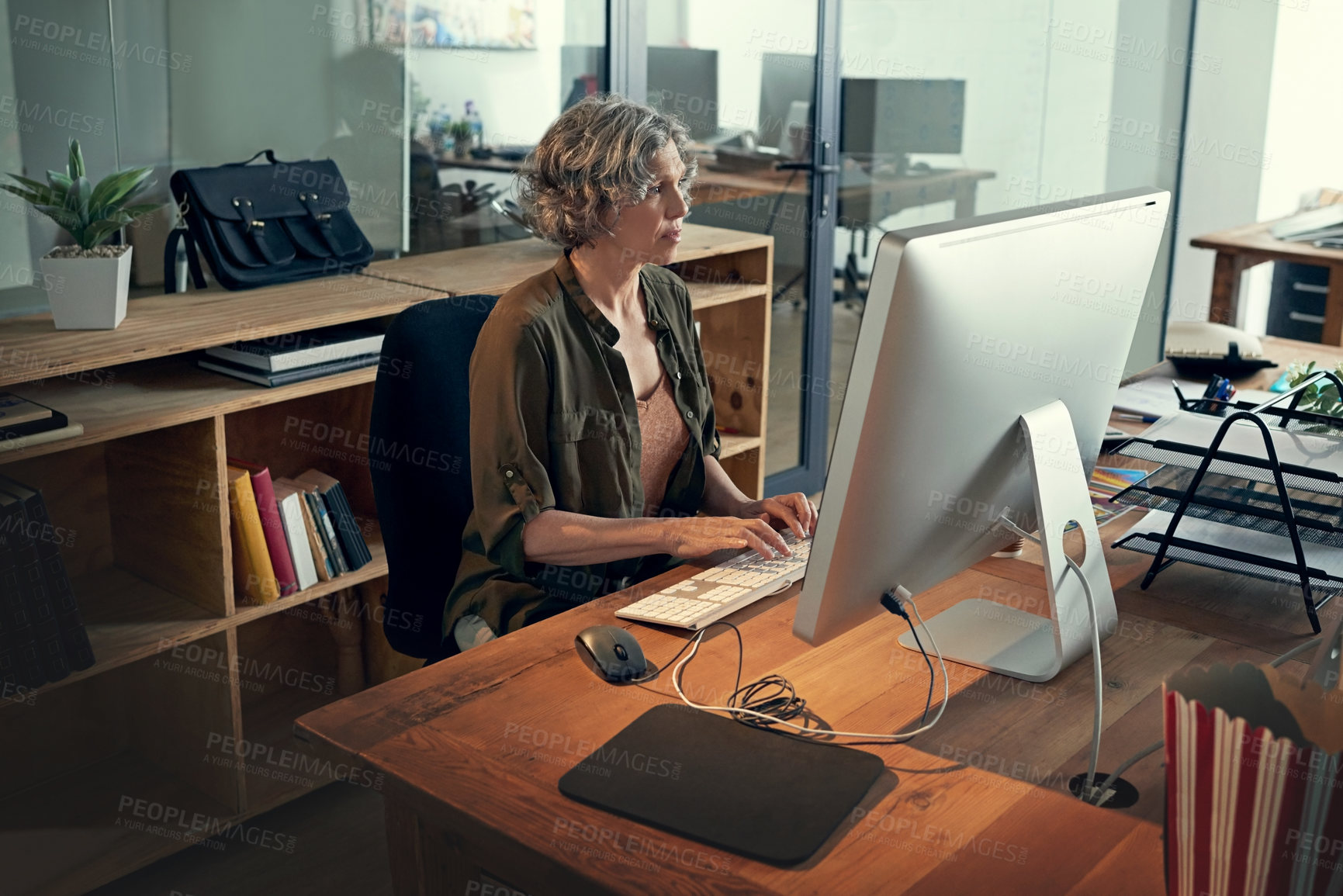 Buy stock photo Cropped shot of a mature businesswomen working on a computer in an office