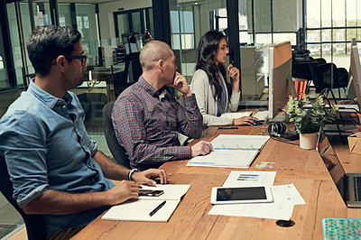 Buy stock photo Cropped shot of a group of businesspeople discussing something on a computer in an office