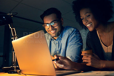 Buy stock photo Cropped shot of two colleagues working late on a laptop in an office