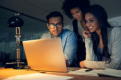 Buy stock photo Cropped shot of a group of businesspeople working late on a laptop in an office