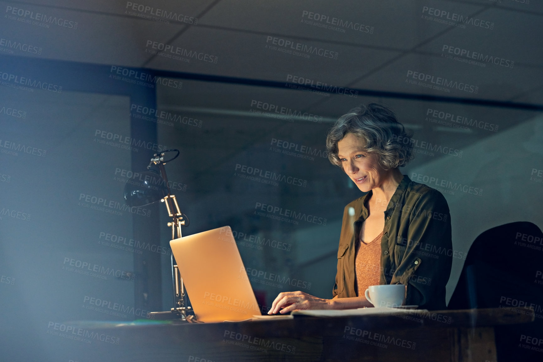 Buy stock photo Cropped shot of a mature businesswomen working late on a laptop in an office