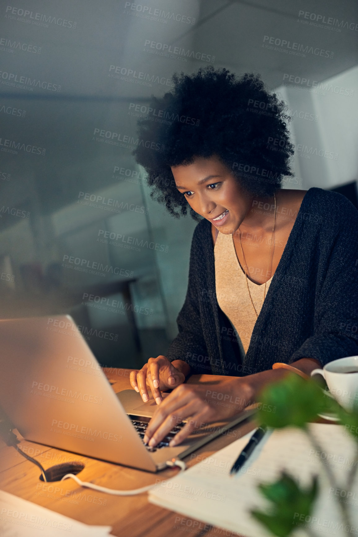 Buy stock photo Cropped shot of a young businesswoman working late on a laptop in an office