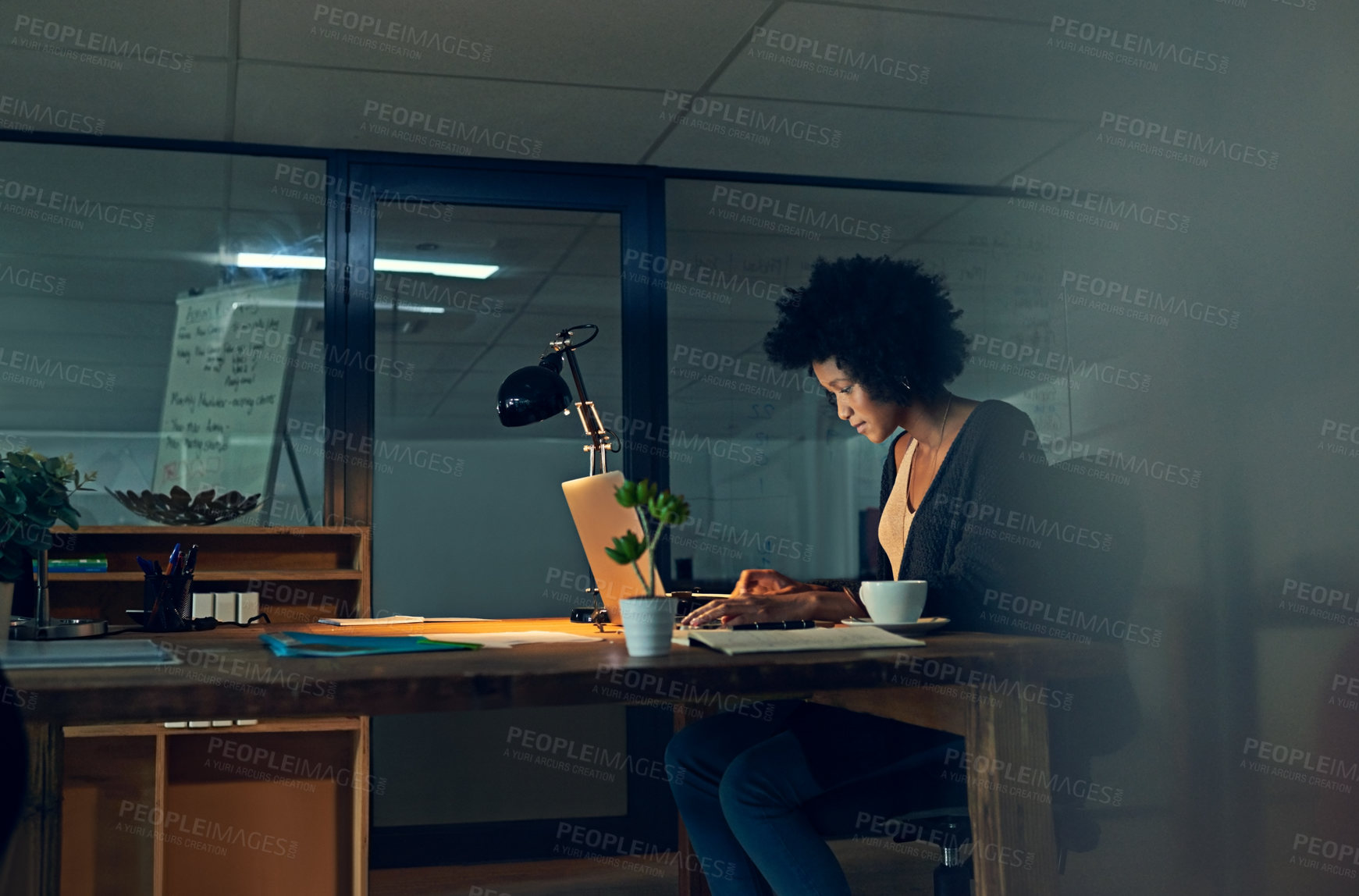 Buy stock photo Cropped shot of a young businesswoman working late on a laptop in an office