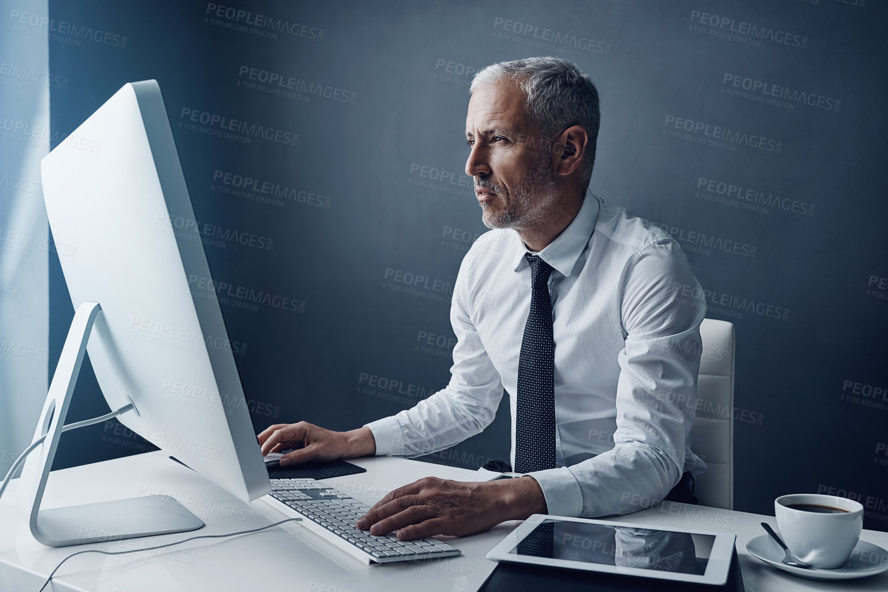 Buy stock photo Typing auditor, computer and elderly man in studio, working and isolated on a dark background mockup. Focus, writing or serious executive at desktop for reading email, research or business accountant