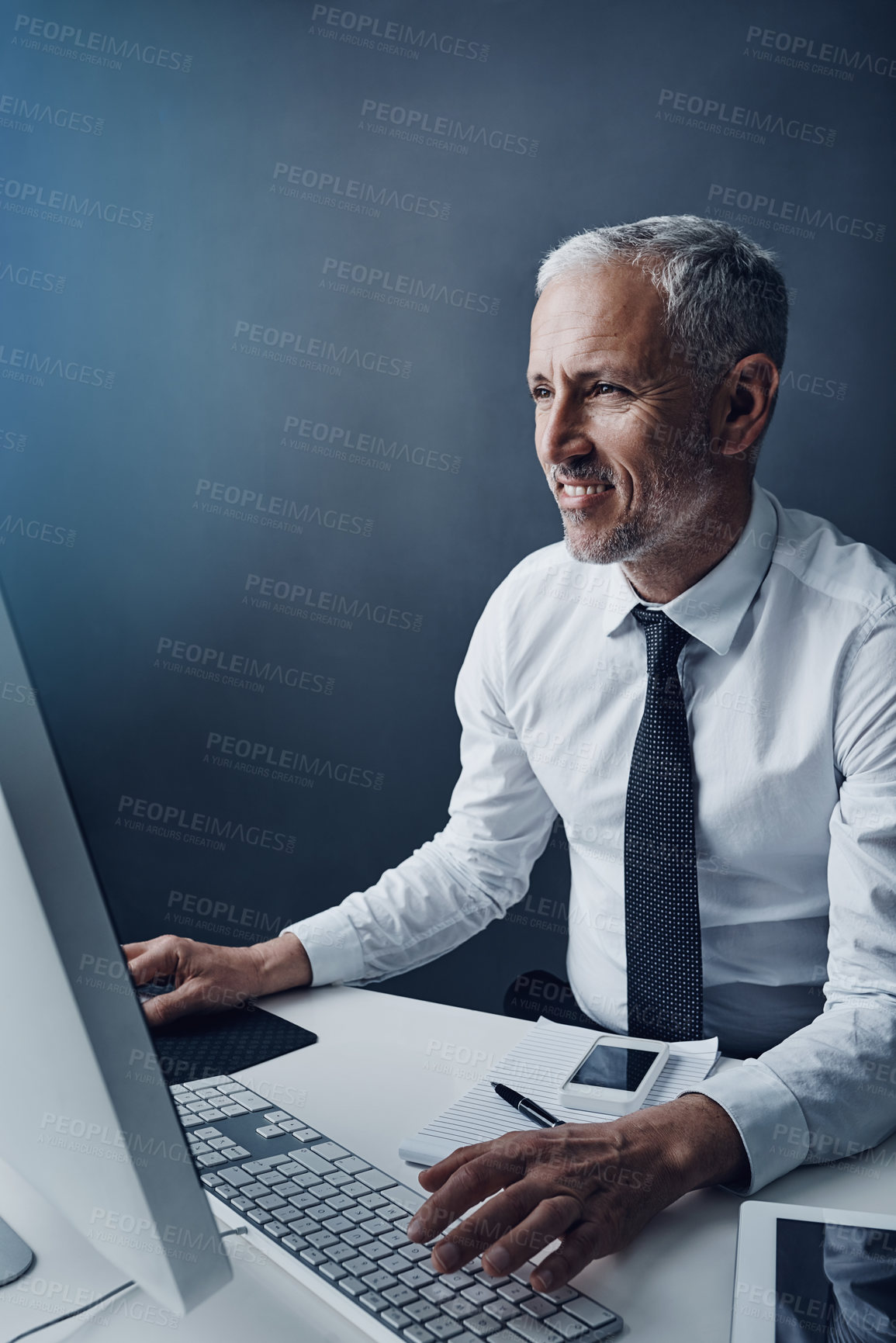 Buy stock photo Typing accountant, computer and mature man in studio, working and isolated on a dark background mockup. Focus, writing and happy manager at desktop for reading email, research or business auditor.
