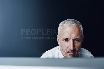 Buy stock photo Cropped shot of a mature businessman working on his computer