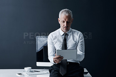Buy stock photo Ceo, tablet and senior man at desk in studio isolated on a dark background mockup space. Technology, reading and serious manager focus on working on project, email or online research for business app