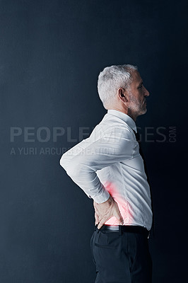 Buy stock photo Injury, feeling and a businessman with back pain at work, spine problem and tired from stress. Serious, backache and a mature corporate employee touching body isolated on a black background in studio