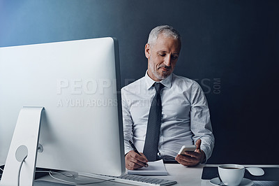 Buy stock photo Phone, computer and business man at desk online for social media, internet and browse website in office. Networking, corporate worker and mature male person on smartphone, writing notes and planning