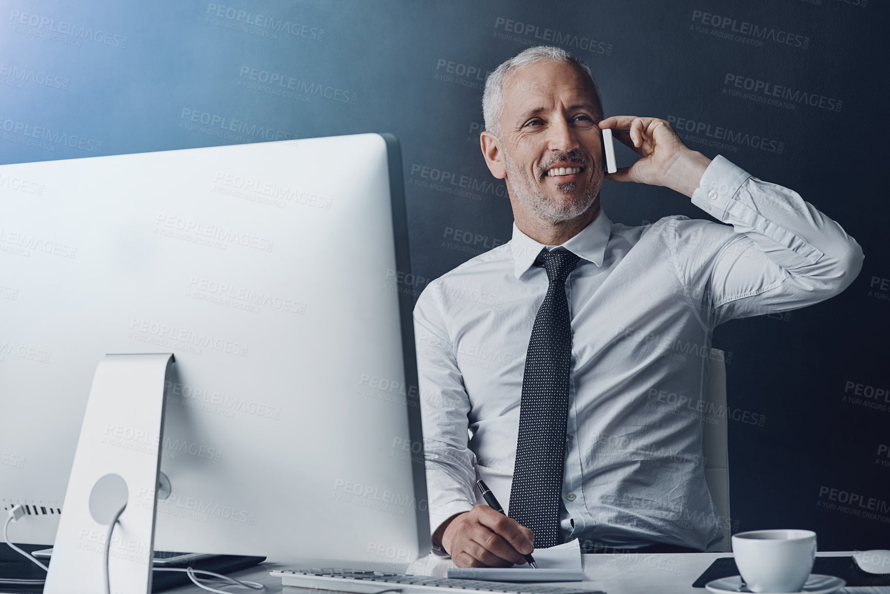 Buy stock photo Technology, mature businessman on a phone call and against a studio background at his desk taking notes. Online communication, social networking with client and male person on smartphone talking