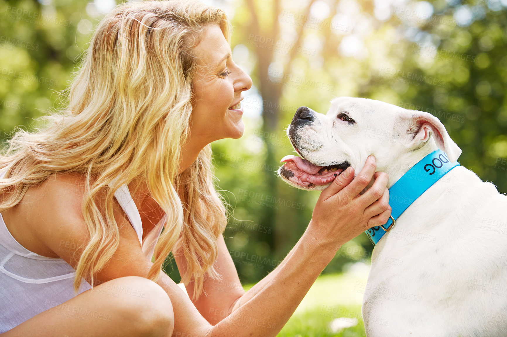 Buy stock photo Shot of a young woman spending time with her dog at the park