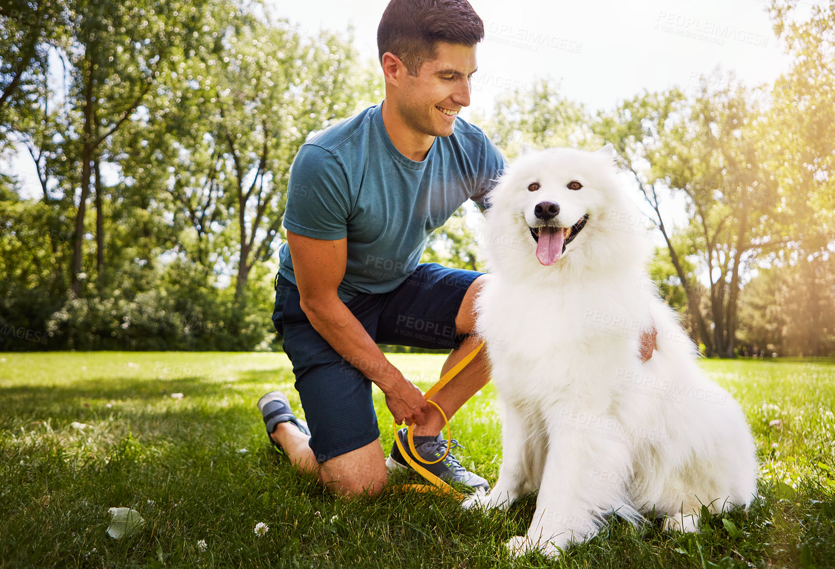 Buy stock photo Shot of a handsome young man walking his dog in the park