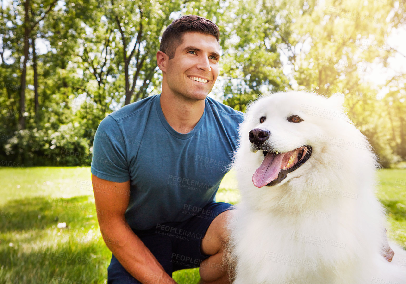 Buy stock photo Shot of a handsome young man walking his dog in the park