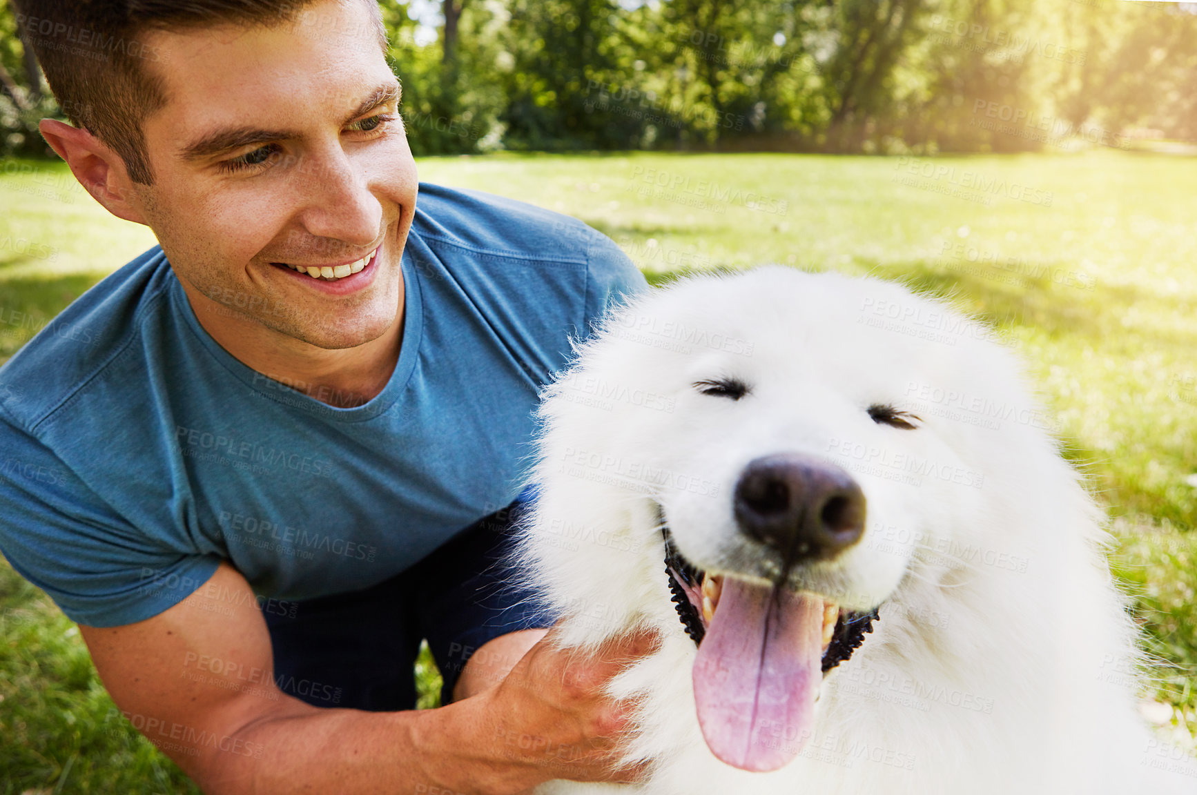 Buy stock photo Shot of a handsome young man walking his dog in the park